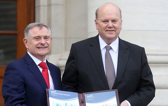 Labour Party Minister for Public Expenditure and Reform Brendan Howlin TD holds a copy of the Comprehensive Expenditure Report with Fine Gael Minister for Finance Michael Noonan TD at Government Build