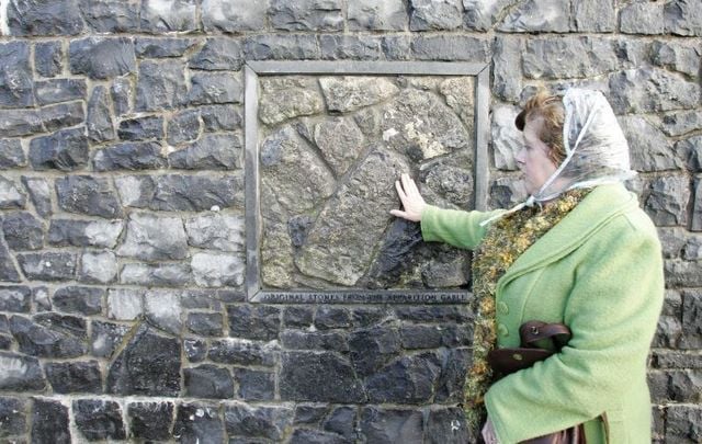 October 31, 2009: A woman touching the original stone from the apparition gable outside the shrine in Knock, Co Mayo.