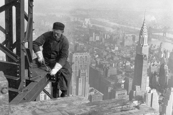 Workman on the framework of the Empire State Building, with the Chrysler Bulding in the background. 