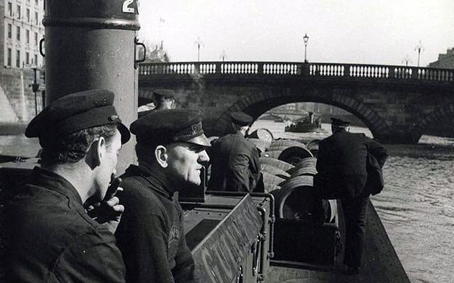 Guinness workers transport barrels of the black stuff up the River Liffey by barge.