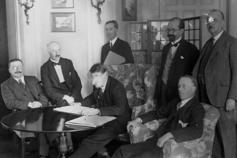 View of members of the Irish delegation at the signing of the Irish Free State Treaty between Great Britain and Ireland, London, England, December 6, 1921: seated from left, Sinn Fein founder Arthur Griffith, Eamon Duggan, Irish Minister for Finance Michael Collins, and politician Robert Barton. Standing from left are author Robert Erskine Childers, lawyer George Gavan Duffy, and John Chartres. (Getty Images)