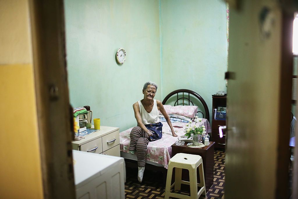 Former leprosy patient Tereza Alves dos Santos, 71, sits in her room in Hospital Curupaiti, part of a former leprosy colony, on June 10, 2015 in the Jacarepagua neighborhood of Rio de Janeiro, Brazil. Image: Mario Tama/Getty Images.