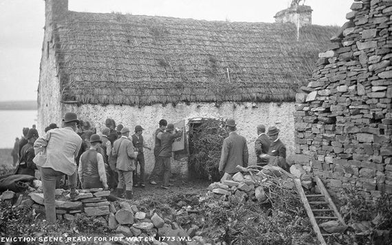 Police shield themselves against hot water thrown by tenants while carrying out an eviction. (Via: NLI)