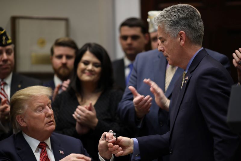 President Donald Trump receives a memorial bracelet of Navy Seal Ryan Larkin, son of Frank Larkin (R), a retired Navy Seal, during a signing ceremony for an executive order at the White House on the “National Roadmap to Empower Veterans and End Veteran Suicide” March 5, 2019 in Washington, DC. Larkin's son Ryan, also a Navy Seal, took his own life due to the effects of traumatic brain injury sustained throughout his military career. (Getty Images)