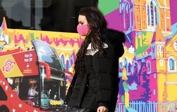 Woman walking down O'Connell Street, wearing face mask. 