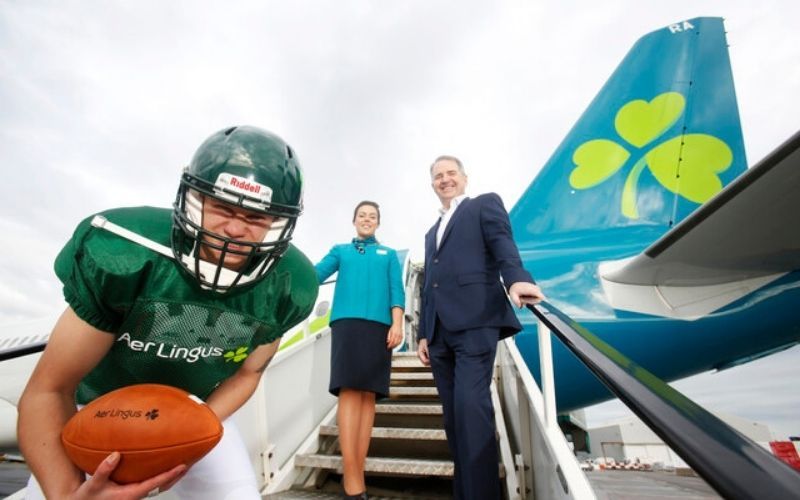Aer Lingus is delighted to support the return of US College Football to the Aviva Stadium- Aer Lingus COO Peter O’Neill with Cabin Crew Brohna Tinnelly and Harry Cameron as an American Footballer Aer Lingus is delighted to support the return of US College Football to the Aviva Stadium- Aer Lingus COO Peter O’Neill with Cabin Crew Brohna Tinnelly and Harry Cameron as an American Footballer