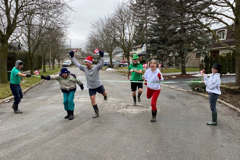 The wellie race's "photo finish" in Canada ... trailed by an oversized leprechaun! (Courtesy Rosaleen Crotty)