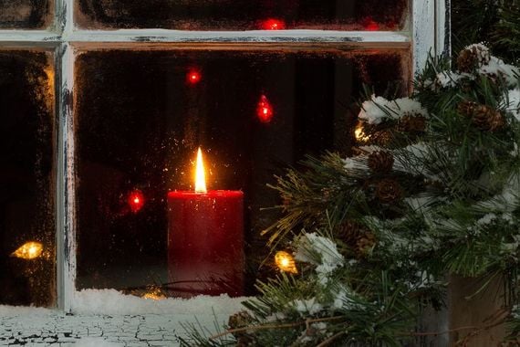 A welcoming candle in a window at Christmas. A welcoming candle in a window at Christmas.