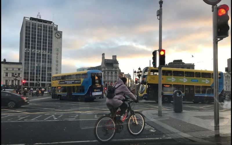 Driving from Dublin Airport by taxi over the O’Connell Bridge and River Liffey, cars, double decker buses, bicyclists, cars and pedestrians merge near the D’Olier Street and O’Connell Street Lower, Dublin, about 4 pm, January 2, 2019. The large building on the left with the Heineken advertisement on the facade is called the O’Connell Bridge House. Learn more about the architecture of the large 1965 building, and what the locals think of the structure. (Photo by Jannet L. Walsh.)