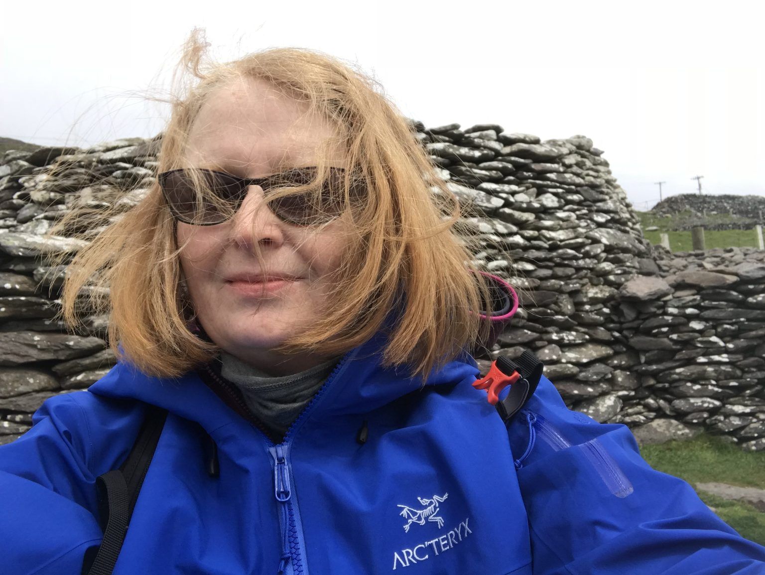 Wind and rain on the Dingle Peninsula – Jannet L. Walsh takes a selfportrait at Fahan Beehive Huts, 2018, Ventry, County Kerry, Ireland. Wind and rain on the Dingle Peninsula – Jannet L. Walsh takes a selfportrait at Fahan Beehive Huts, 2018, Ventry, County Kerry, Ireland.