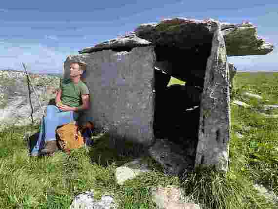 Eoin Warner by a prehistoric tomb in the Burren. (Crossing the Line Productions)