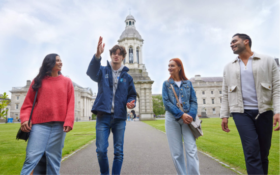 A tourguide walking visitors through Trinity College Dublin's quad.