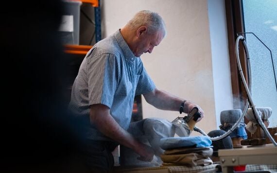 Hanna Hats' worker, Bernard ironing a hat, in their Donegal workshop.