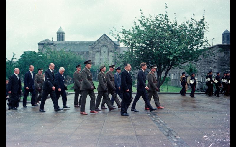 June 28, 1963: President John F. Kennedy (center) attends a wreath laying ceremony at the Arbour Hill Cemetery in Dublin, Ireland; Taoiseach (Prime Minister) of Ireland, Seán Lemass, walks beside President Kennedy. Also pictured: Air Force Aide to the President, Brigadier General Godfrey T. McHugh; Minister for External Affairs of Ireland, Frank Aiken; U.S. Chief of Protocol, Angier Biddle Duke; and Ambassador to Ireland, Matthew H. McCloskey (all walking behind the President). (Public Domain / Cecil Stoughton. White House Photographs. John F. Kennedy Presidential Library and Museum, Boston)