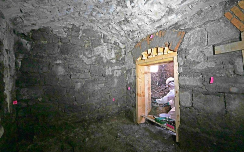 A forensic excavation team member working inside the subterranean vaulted structure. (ODAIT)