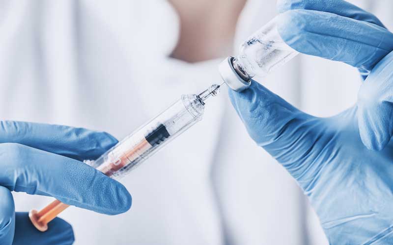 A doctor holds the flu vaccine. Credit: iStock