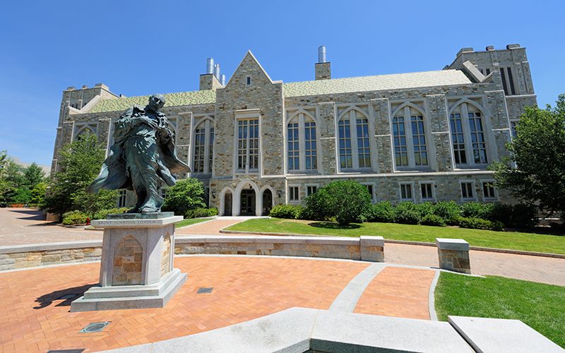 Saint Ignatius Loyala statue in front of Boston College building.