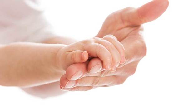 Baby holding father's hand. Credit: iStock