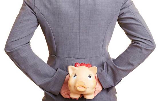 Person holds piggy bank behind their back. Credit: iStock