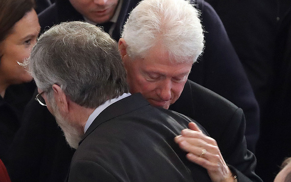 Former president Bill Clinton hugs Gerry Adams at Martin McGuinness' funeral.