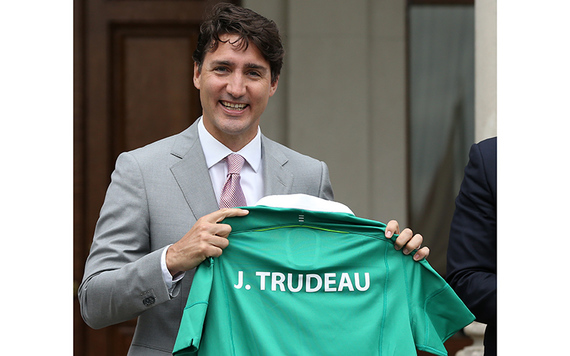 Justin Trudeau holding an Irish jersey printed with his name, presented to him by the Irish leader.