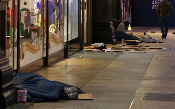 Homeless line the road, on Henry Street, Dublin 1 at night.