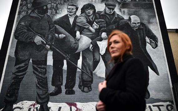 A family member of a Bloody Sunday victim stands before the famous murder in Bogside, Derry.