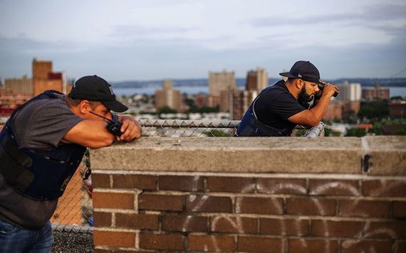 A watchful eye: Two NYPD cops in surveillance mode on a roof top.