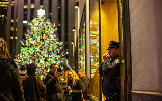 An officer keeps warm by the Rockefeller Center Christmas tree.