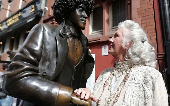 A statue of Phil Lynott off Grafton Street being admired by Philomena Lynott.