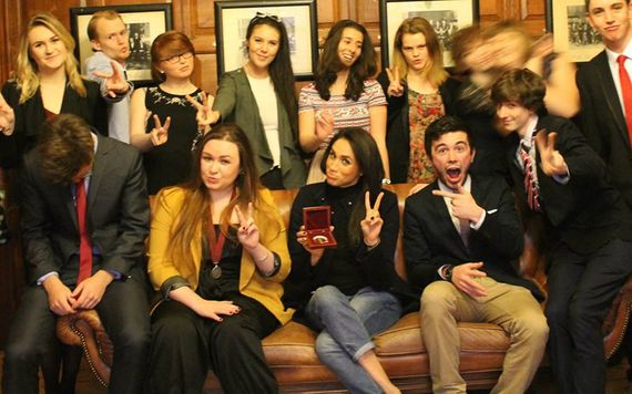Members of the Phil, with Meghan Markle (center), including James Wilson, on the left arms of couch.