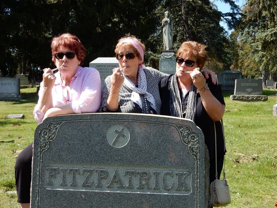 Kate (center) and her sisters Marilee (left) and Peggy smoke Irish clay pipes at the Fitzpatrick family gravestone. Kate and Marilee bought the clay pipes at the Claypipe Visitor Center in Knockcroghery, Co. Roscommon, Ireland.