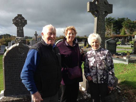 Kate (center) and her distant cousins Mick and Anna Harney in front of a Harney gravestone in the All Saints Catholic Church cemetery in Newtown, Co. Waterford.
