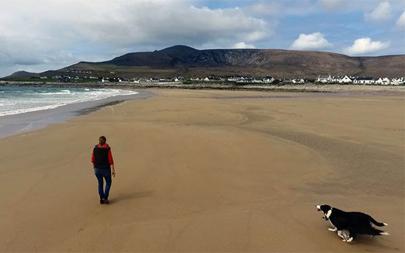 A woman walks her dog on Dooagh beach, Achill Island, Mayo.