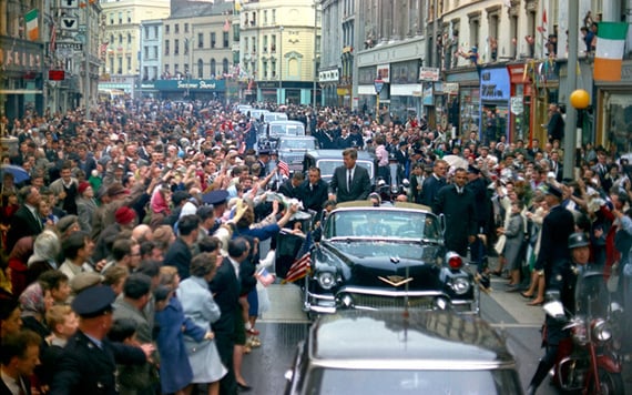 President John F. Kennedy stands in an open car while a large crowd cheers as the President’s motorcade passes through Cork, Ireland. Robert Knudsen. White House Photographs. John F. Kennedy Presidential Library and Museum, Boston