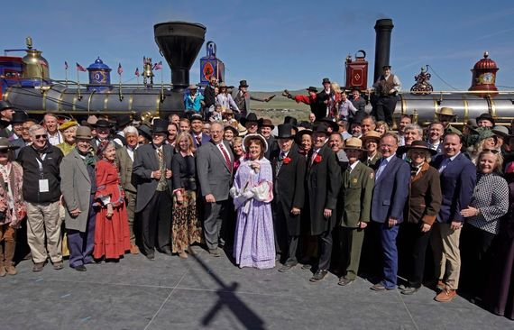 With dignitaries in the foreground, men reenact the historic Champagne Toast with the Jupiter (L) and the 119 steam engines for the 150th anniversary of the driving of the Golden Spike on May 10, 2019 in Promontory, Utah. The driving of the Golden Spike completed the Transcontinental Railroad that liked both coast of the United States for the first time. (Photo by George Frey/Getty Images)
