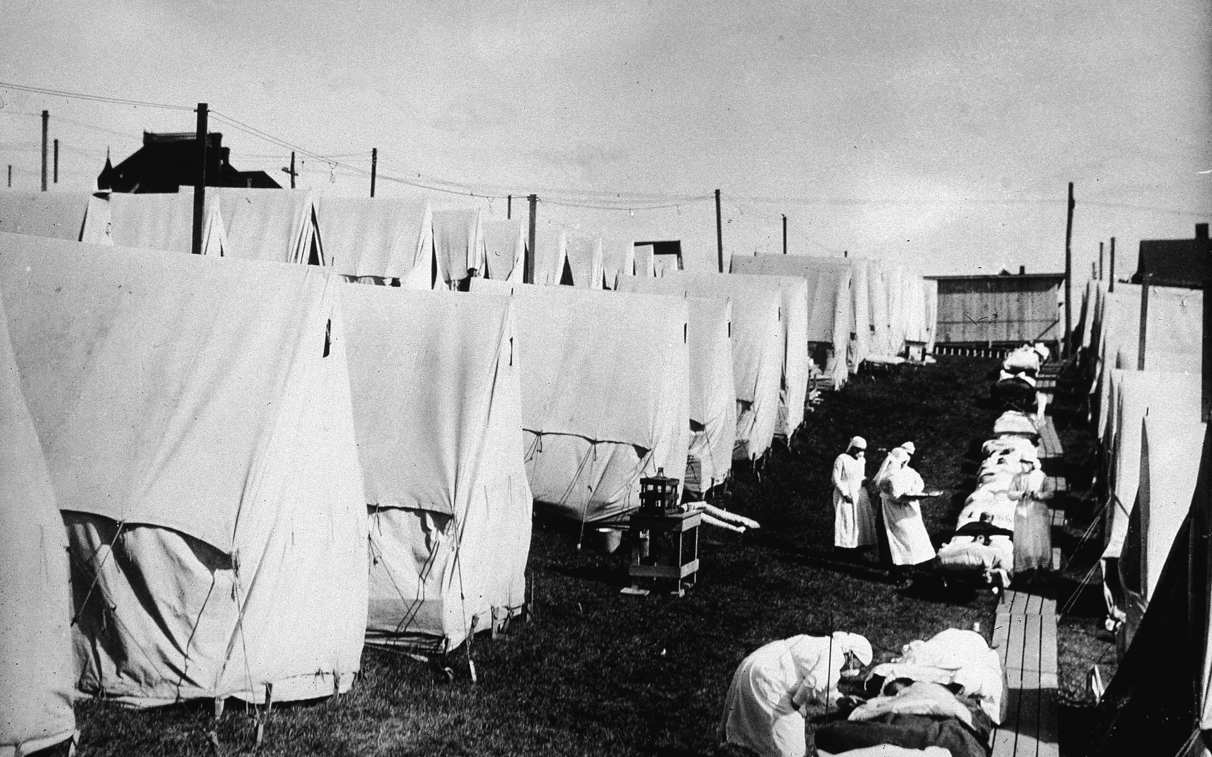 Nurses care for victims of a Spanish influenza epidemic outdoors amidst canvas tents during an outdoor fresh air cure, Lawrence, Massachusetts, 1918 (Photo by Hulton Archive/Getty Images)